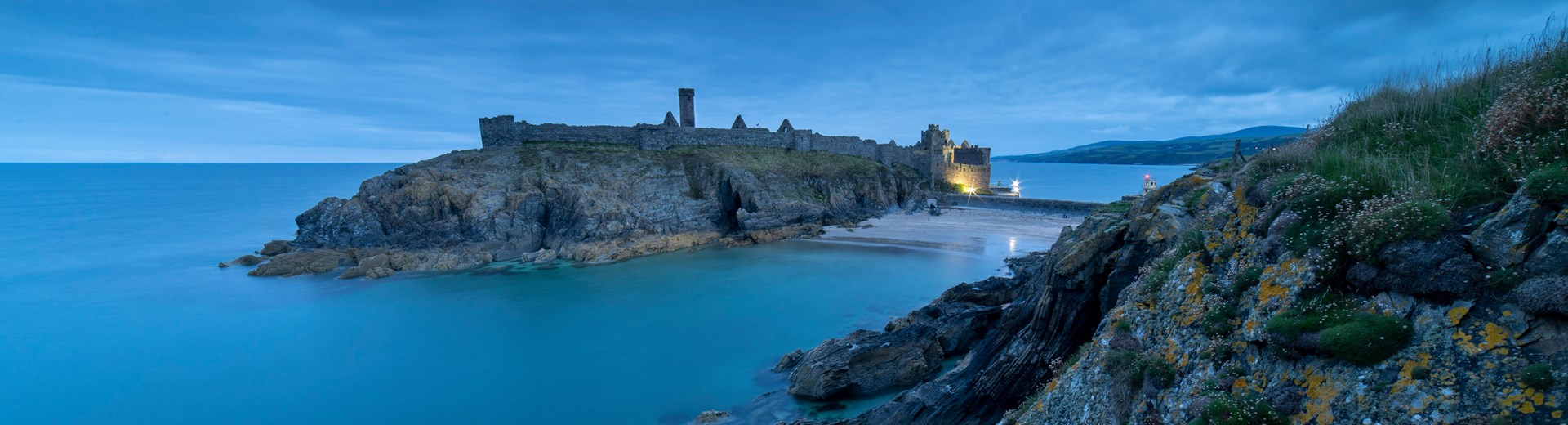Peel castle and coastline at night time. The Castle is very old and in ruins. 