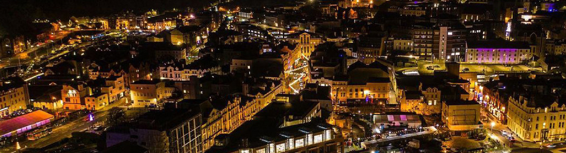 An aerial view of Douglas in the Isle of Man at night showing the capital lit up