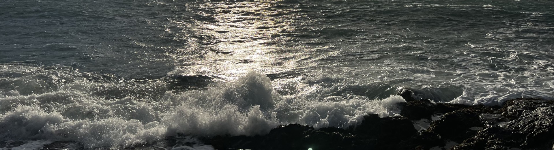 The Isle Of Man taken from above. Green rolling hills and a coastline with blue skies. 